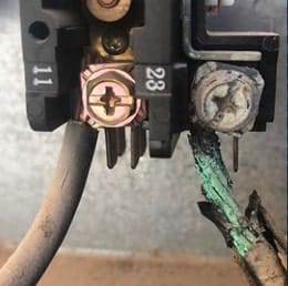Burned contactor terminals and corroded wiring found on an AC unit during a repair call
